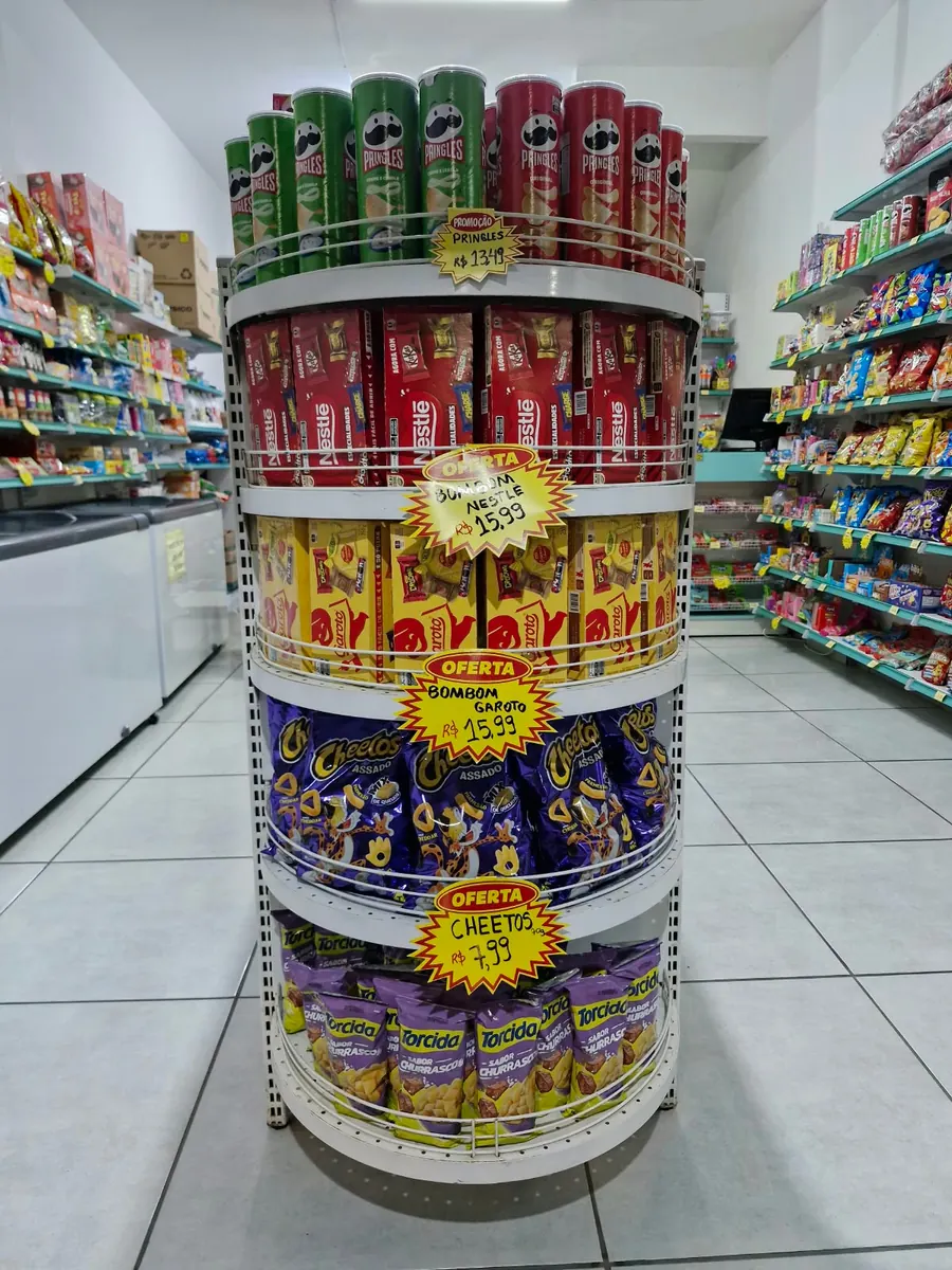 Expositor central com batatas, chocolates e outros produtos.