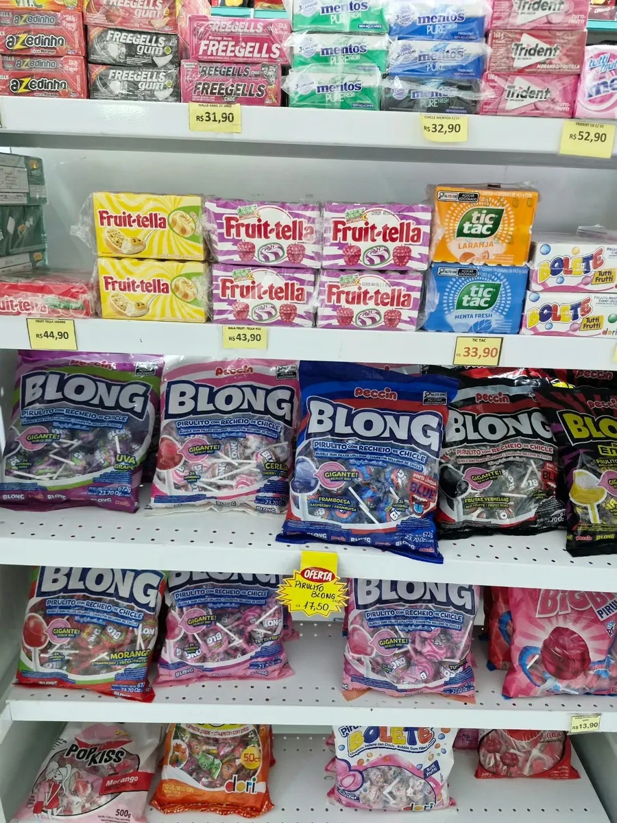 Variedade de balas e chicletes nas prateleiras.